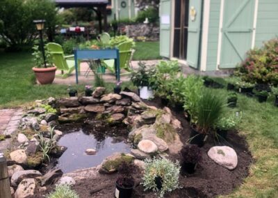 This fun project in Hudson, NH had the crew revisiting and revamping one of our existing gardens! The Excavator dug out 10 yards of poor soil and replaced it with 10 yards of good soil. Last year , in early July, we planted 100 perennials of which half were shade and the others sun loving. These new 80 perennials really made the front side and back yard pond garden quite lovely.