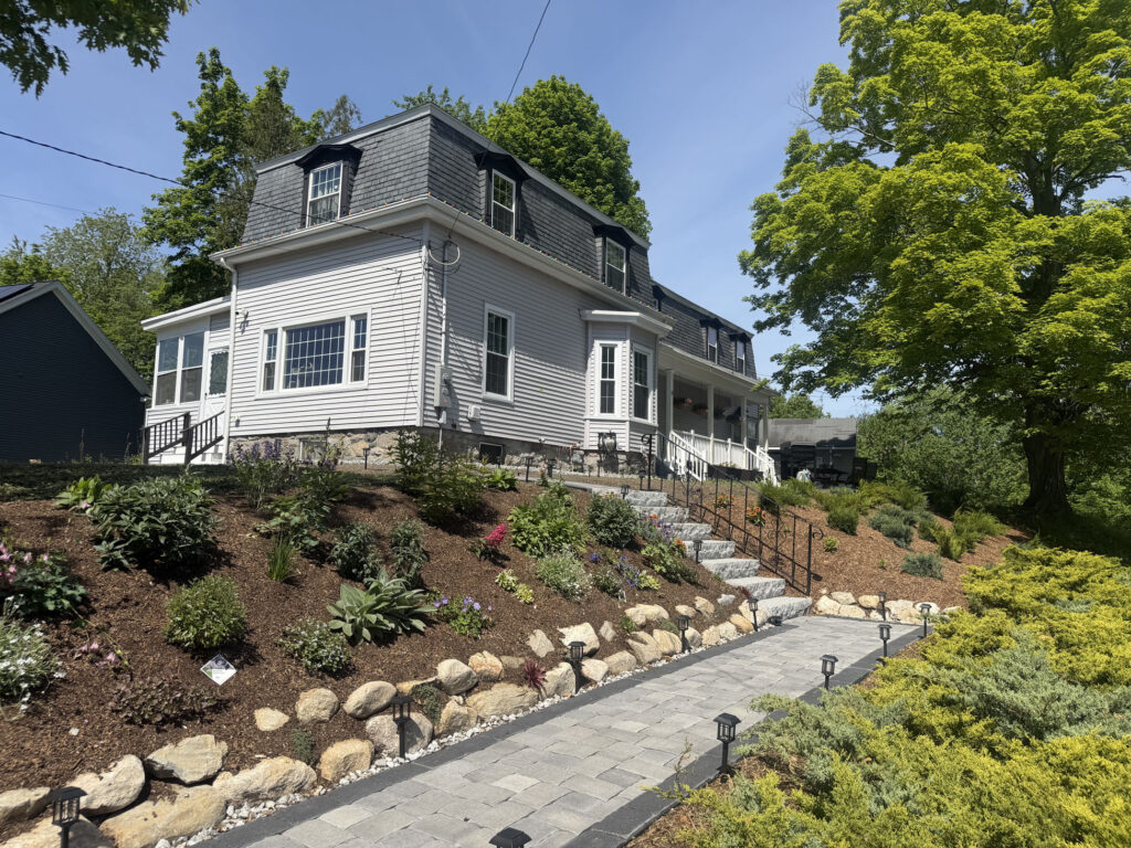 About 15 yards of rich garden soil were brought in to prepare the new beds. On the slope, we planted approximately 50 spreading junipers and 50 perennials, giving the hillside a mix of evergreen structure, texture and seasonal color.