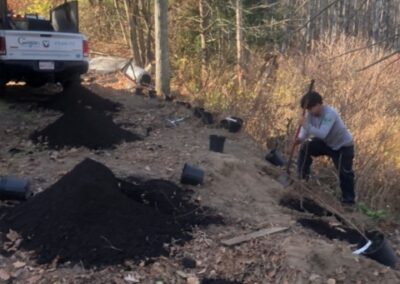 Garden Maintenance and Garden Installation in Merrimack, NH. Our Merrimack, NH client had us pull out honeysuckle bushes and bittersweet with the Dingo. We then planted 25 Staghorn and 25 Low Grow Sumac along a riverbank. Each hole had 3 shovels of compost.