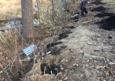 Garden Maintenance and Garden Installation in Merrimack, NH. Our Merrimack, NH client had us pull out honeysuckle bushes and bittersweet with the Dingo. We then planted 25 Staghorn and 25 Low Grow Sumac along a riverbank. Each hole had 3 shovels of compost.